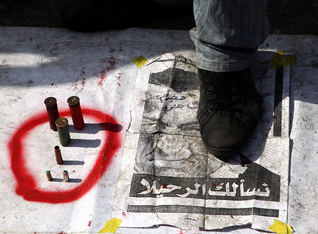 Egypt crisis day 8: An Egyptian man steps on a banner placed on the ground