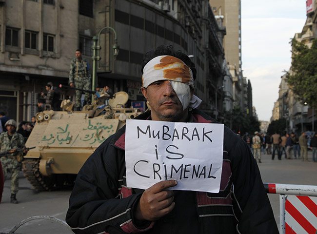 Egypt placards: A wounded demonstrator carries a poster in Cairo