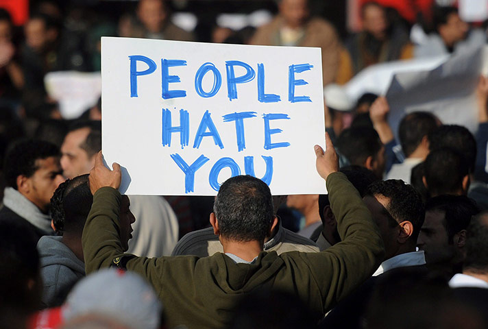 Egypt placards: A demonstrator holds a sign reading 'People hate you' 