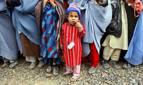 A displaced Afghan child queues to receive winter aid