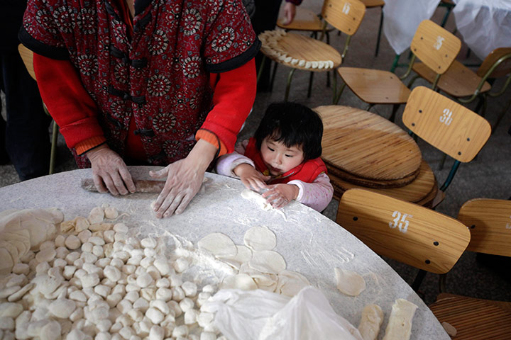 24 hours in pictures: Child makes dumplings ahead of Chinese New Year, China