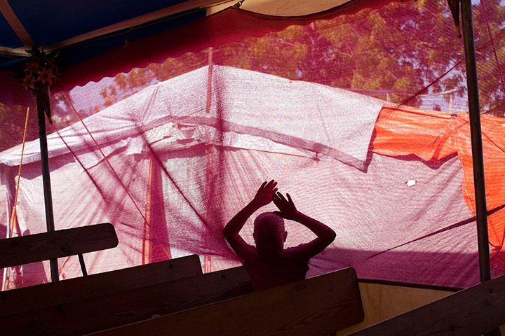 24 hours in pictures: A boy leans against a tent wall, Port-au-Prince, Haiti