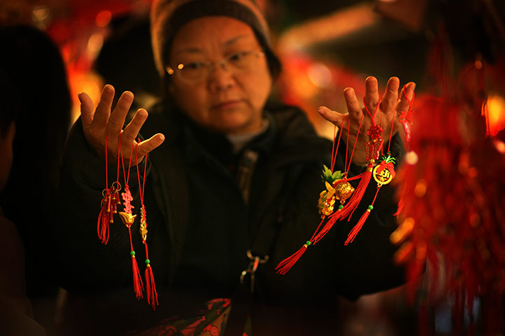 24 hours in pictures: A woman decides on Chinese New Year decorations, Taiwan