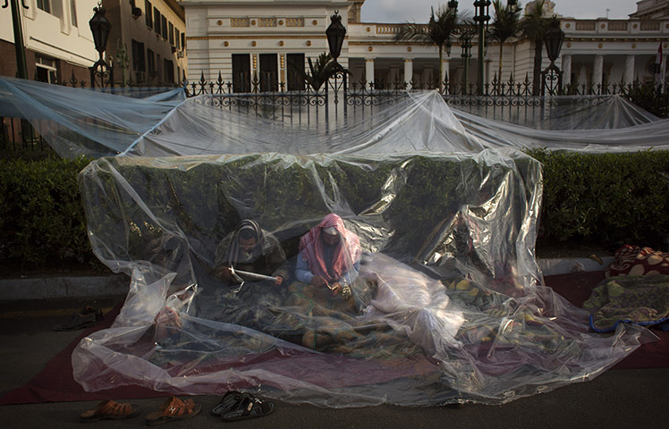 Egypt day 17: Anti-government protesters sit behind plastic sheets outside Parliament 
