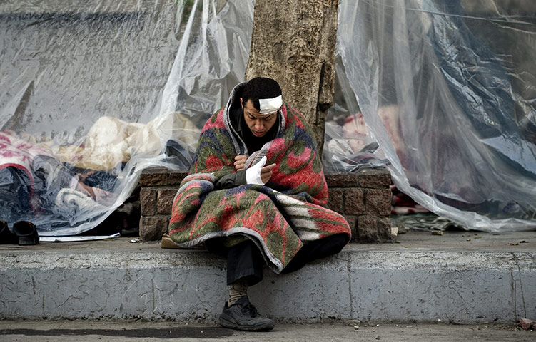 Egypt day 17: An injured anti-government protester reads the Qur'an in Tahrir Square