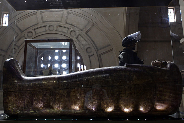 Egypt day 17: A member of the special forces walks past a mummy in the Egyptian Museum