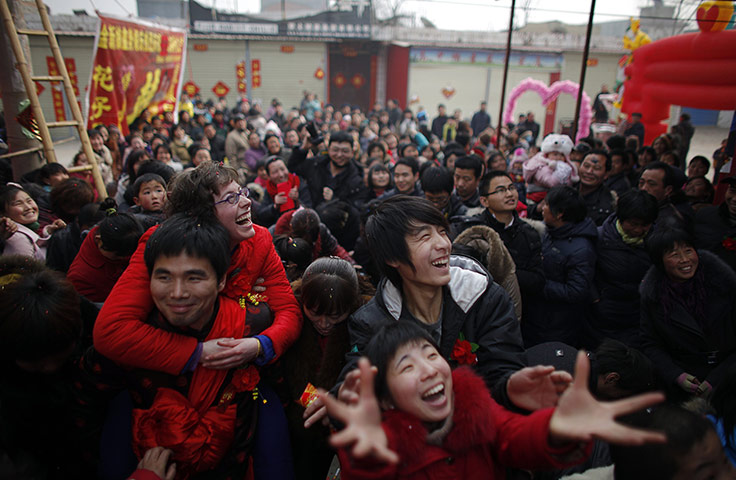 from the agencies: Liu Jian carries his wife Rebecca Kanthor after their wedding
