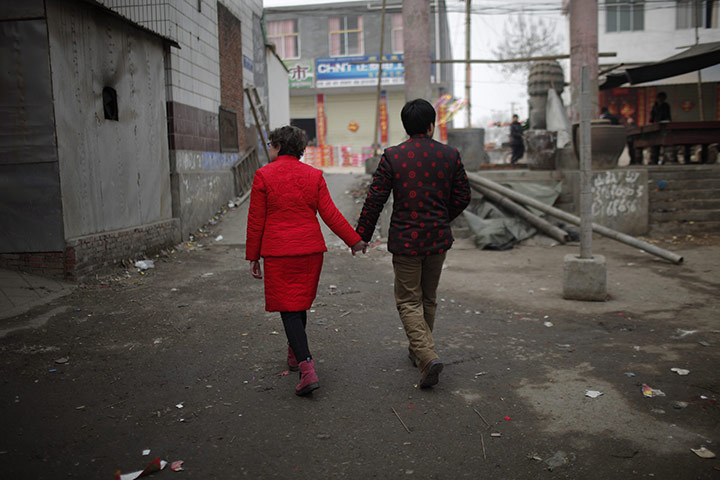 from the agencies: Rebecca Kanthor and Liu Jian walk along an empty street after their wedding