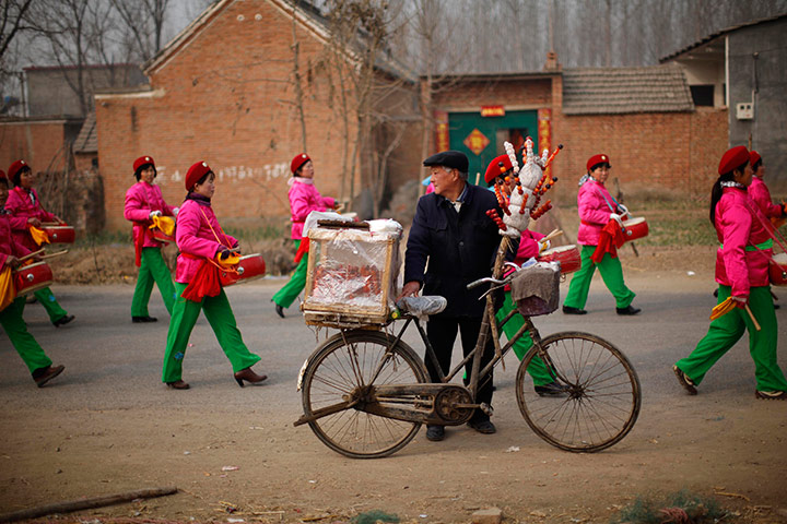 24 hours in pictures: A local vendor watches a traditional Chinese wedding in Dong'an