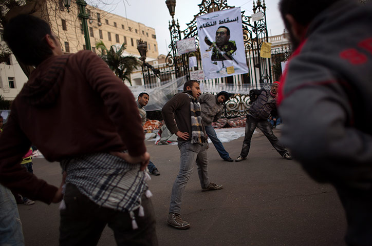 24 hours in pictures: Anti-government protesters stretch in a street, Cairo