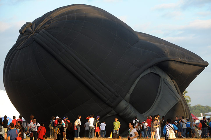24 hours in pictures: Spectators stand in front a partially inflated hot air balloon, Philippines