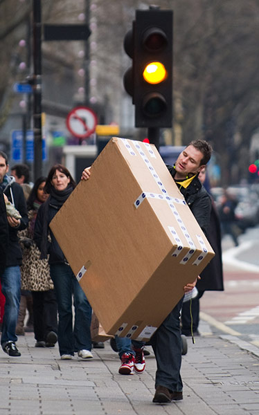 Week in Business: A man carries a large item along Tottenham Court Road