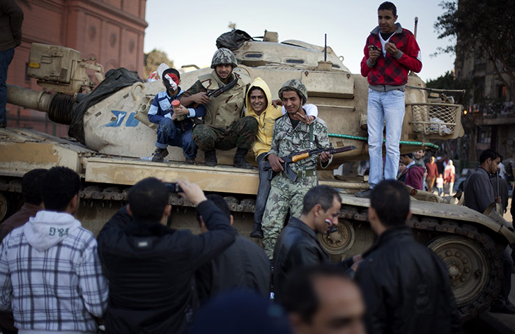 Egypt Day 19: Egyptians next to an Army soldier on top of a tank in Tahrir Square