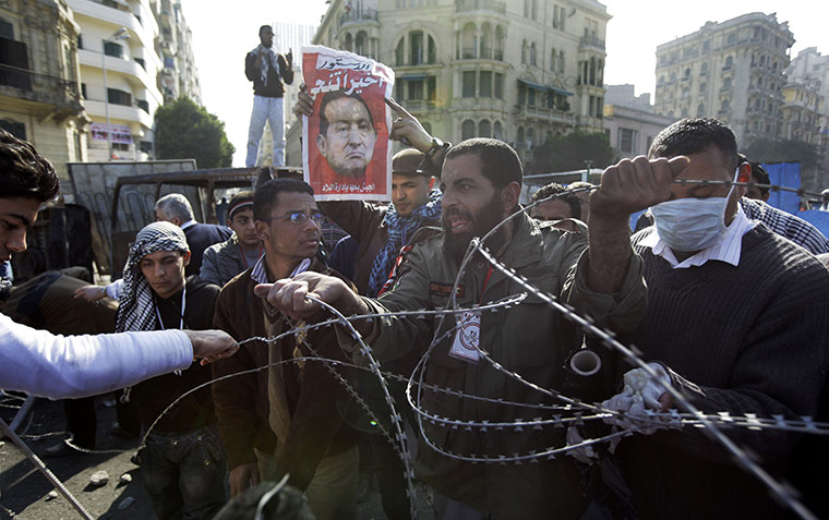 Egypt Day 19: An Egyptian removes razor-wire used at the barricades in Tahrir Square