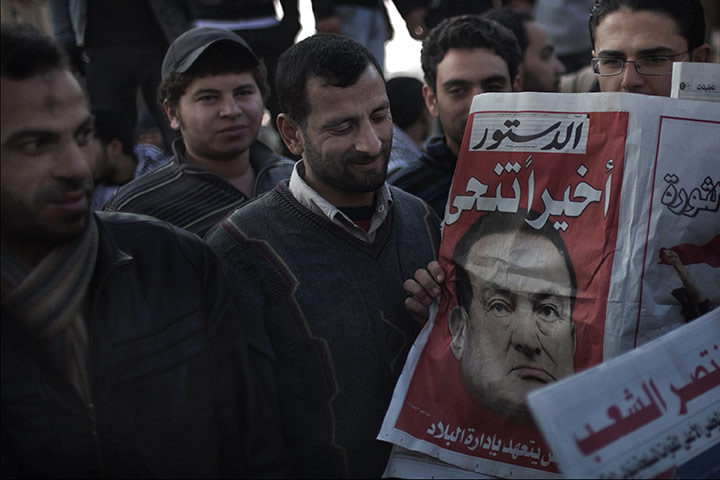 Egypt Day 19: Egyptians read a newspaper on the resignation of Hosni Mubarak