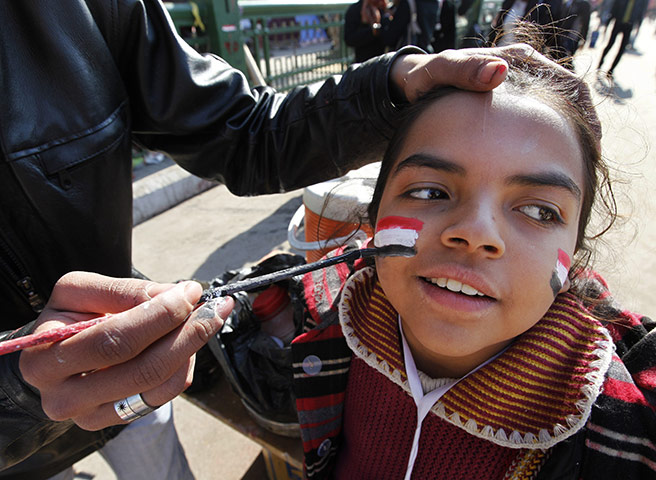 Egypt Day 19: An Egyptian man paints the Egyptian flag on a girls face at Tahrir Square