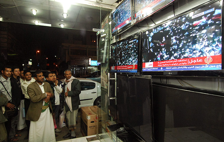 Egypt reaction: Yemeni men look at television footage of