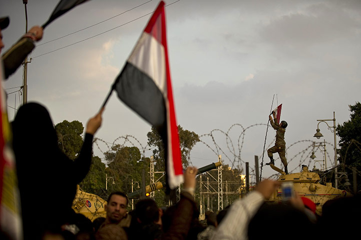 24 Hours: An Egyptian soldier places his national flag on a tank