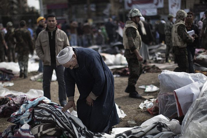 Egypt aftermath: An elderly Egyptian clears his belongings from camp site 