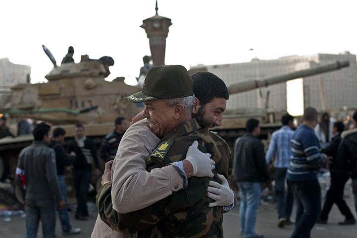 Egypt aftermath: An Egyptian man hugs an army commander at Cairo's Tahrir Square
