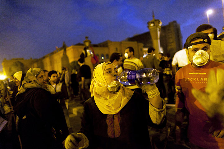 24 hours in pictures: An Egyptian woman drinks water as she helps to clean up Tahrir Square