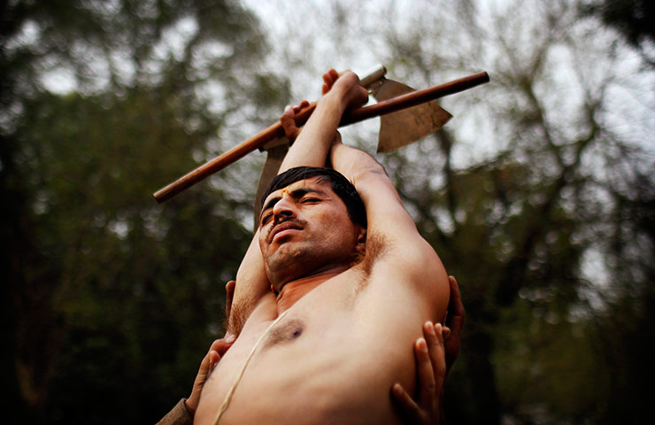 24 hours in pictures: An Indian Hindu worshipper is held up while in trance