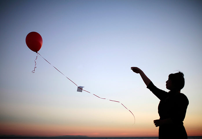 24 hours in pictures: A woman releases a balloon with a note tied to it, Santa Monica