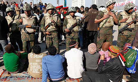 Protesters sit on the ground in front of soldiers in Tahrir Square, Cairo