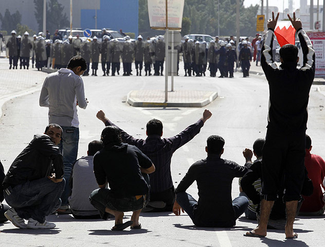 Arab unrest: Bahrain youths demonstrate in front of the police in Manama