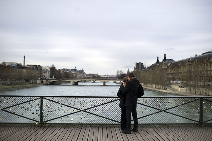Valentine's Celebrations: A couple kiss on the Pont des Arts in Paris