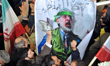 Iranian government supporters hit an image of opposition leader Mir-Hossein Mousavi in Tehran
