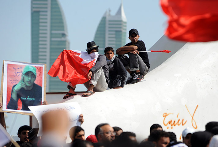 Protests spread: Bahraini mainly Shia protesters wave their flag in Manama's Pearl Square