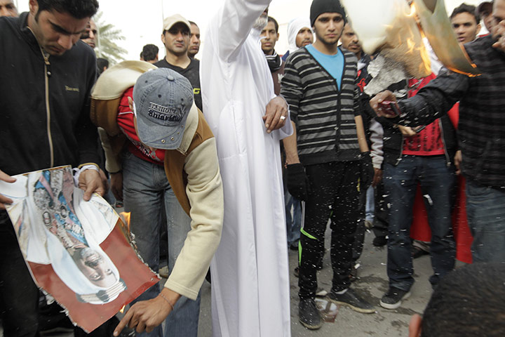 bahrain: Anti-government demonstrators burn a picture of former emir in bahrain