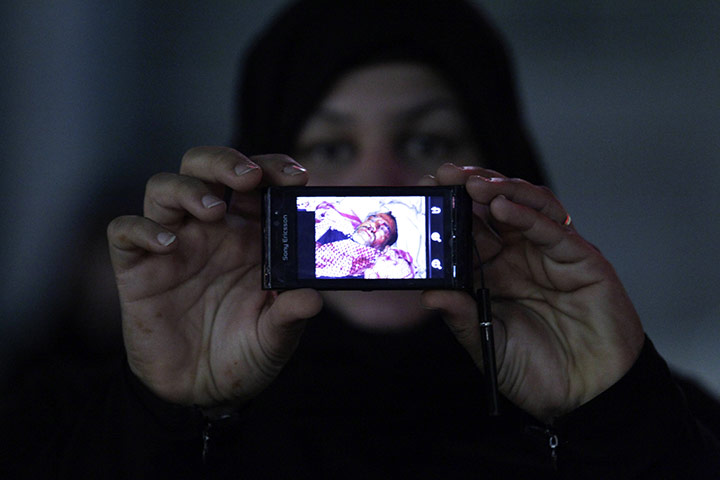 bahrain: A Bahraini anti-government demonstrator shows a pictures of a wounded man