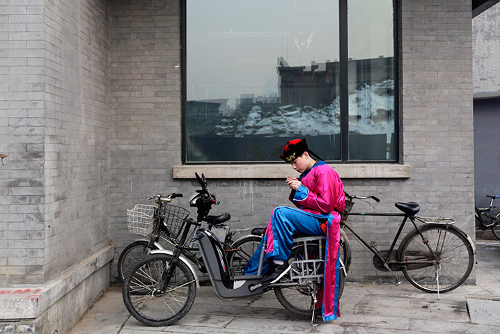 24 hours in pictures: A man dressed in a Qing dynasty costume sits on a bicycle, Beijing
