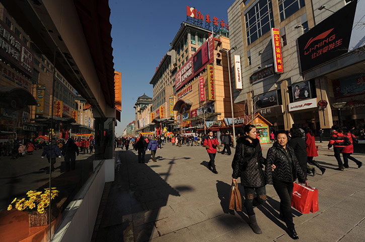 Week in Business: Shoppers walk through a busy retail street in Beijing 