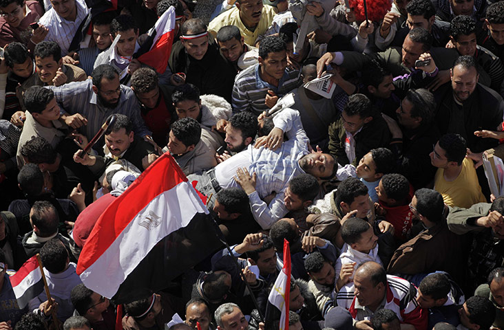 egypt: A man who fainted in the crowd is carried away in Tahrir square