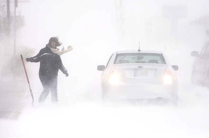US White Out: A stranded motorist reaches for her shovel
