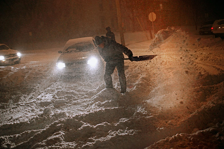 US White Out: A man works to dig a path for his car