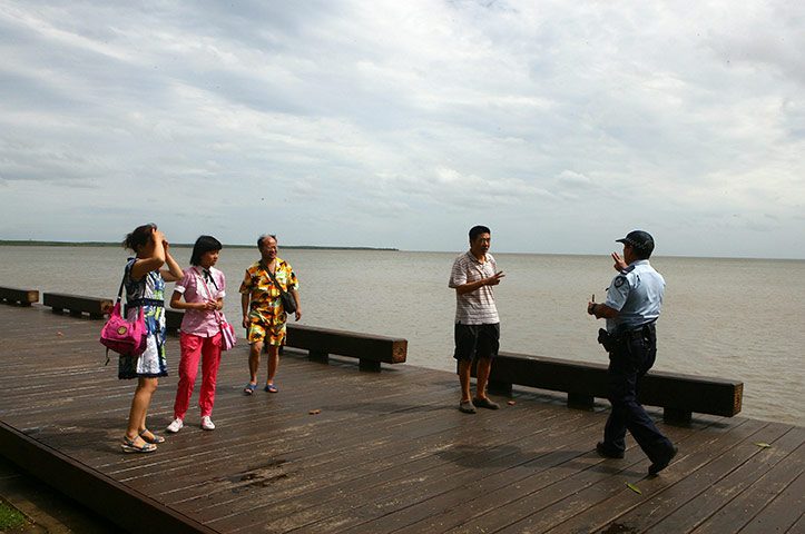 Cyclone Yasi preparations: A police officer asks tourists to vacate the Cairns esplanade