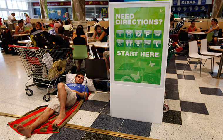 Cyclone Yasi preparations: A man sleeps in an emergency cyclone shelter at a shopping mall in Cairns