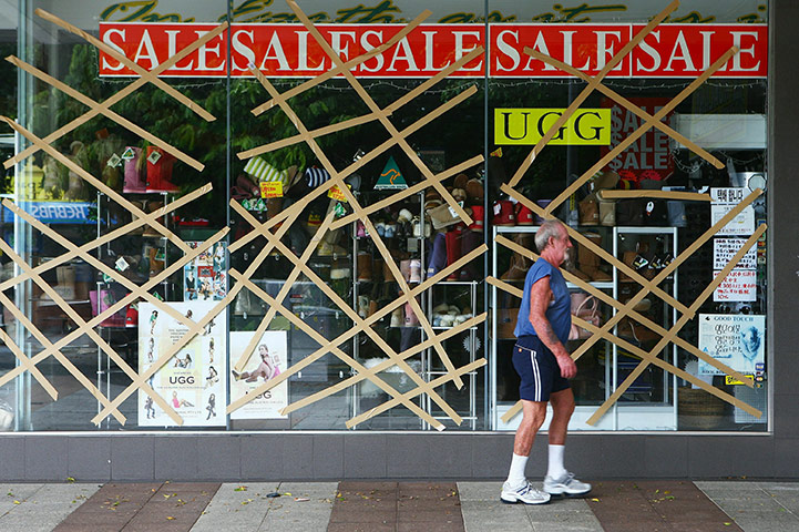 Cyclone Yasi preparations: A local walks past windows taped up in preparation for Cyclone Yasi 