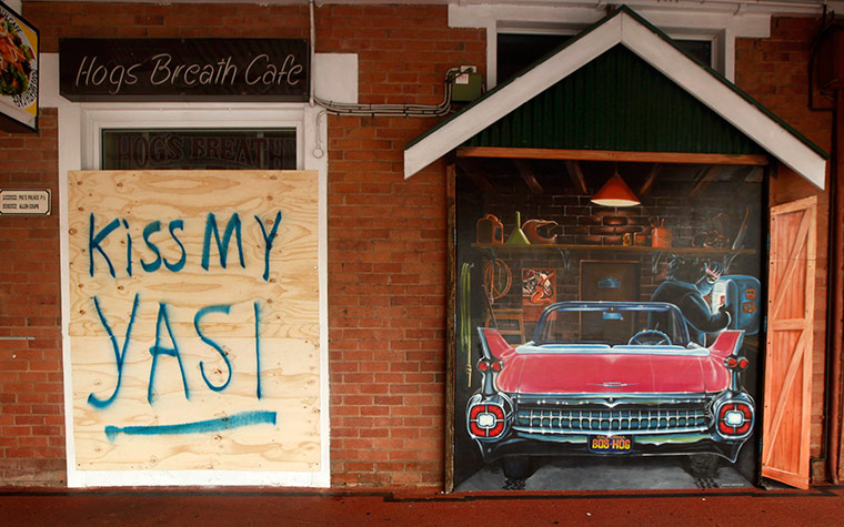 Cyclone Yasi preparations: Board protects front window of a cafe in in Cairns