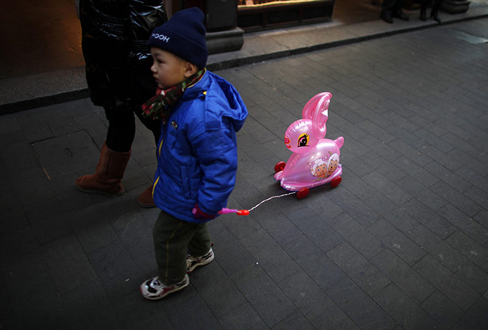 24 hours in pictures: A boy with a toy rabbit walks in Shanghai