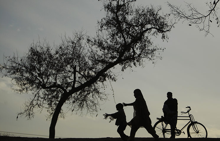 24 hours in pictures: A woman runs after a boy on a bridge in Islamabad, Pakistan