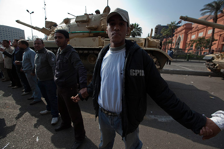 Sean Smith in Cairo: Protestors and demonstrators link arms around around tank in Tahrir Square