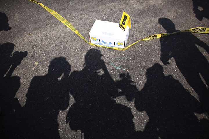 FTA Alexandre Meneghini: Press photographers take photos of a box containing a human head