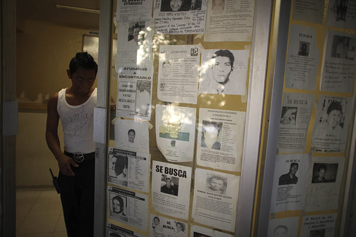 FTA Alexandre Meneghini: An employee at the morgue opens a door with pictures of missing people 