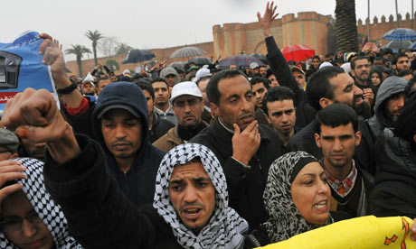 Moroccans raise their hands during a protest demanding broad political reforms, in Rabat, Morocco