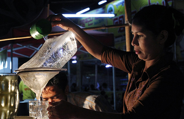 24 hours: Thanlyin, Burma: A vendor sells water to customers at a pagoda festival 